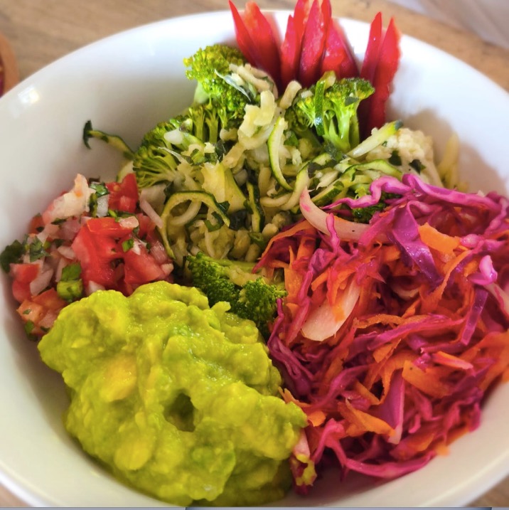 A vivid bowl of fresh vegetables, slaw, salsa and guacamole