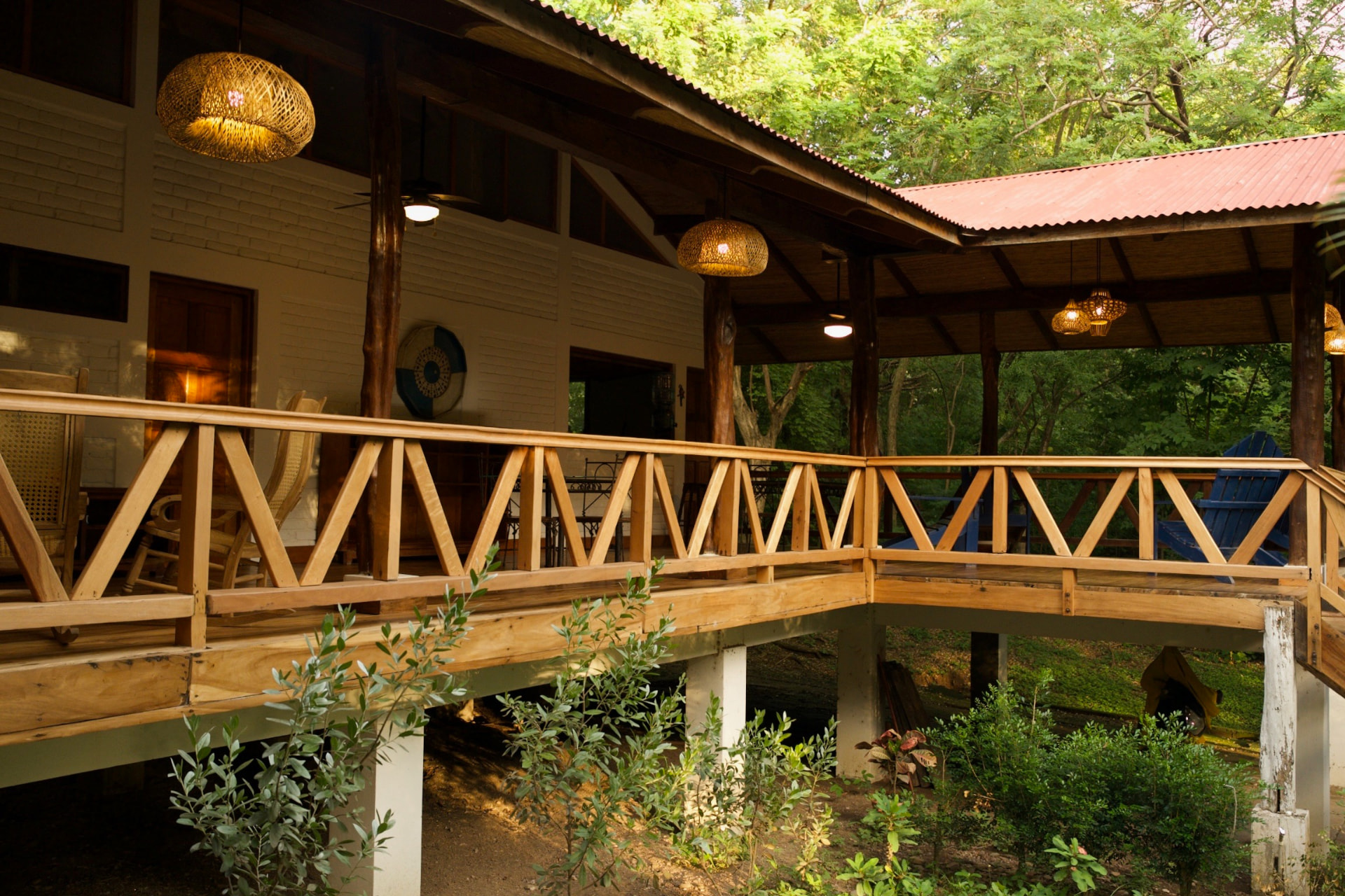 A wooden porch with seating looking out into the surrounding trees