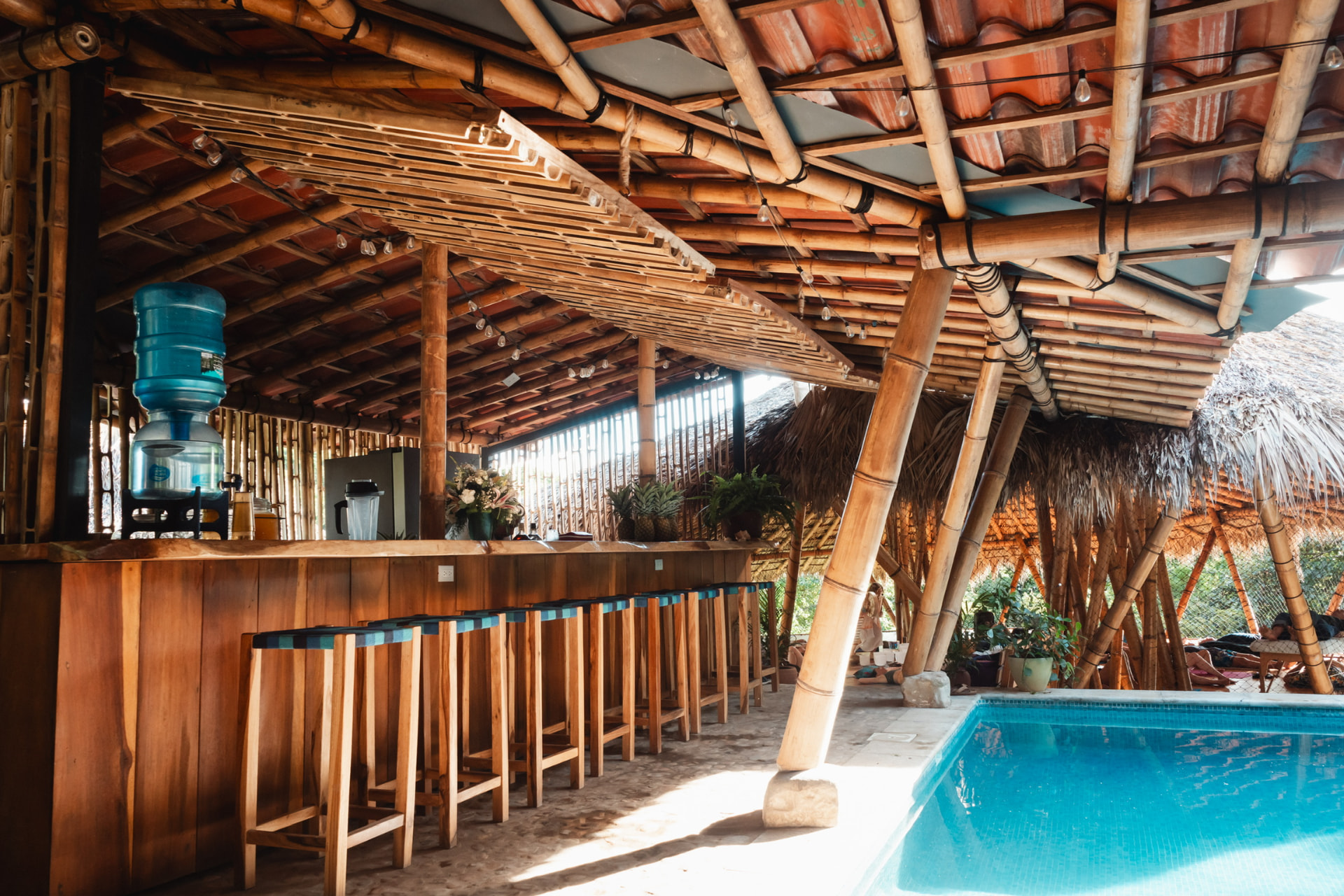 Open-air bamboo bar and wooden stools beside the Sanctuary pool