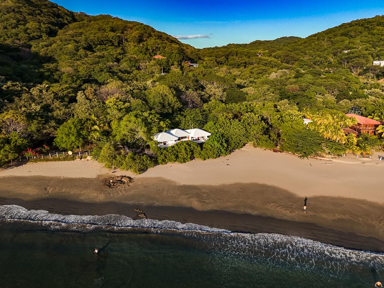 Aerial view of Playa El Coco, the forested hills and Sanctuary on the Beach beside the Pacific