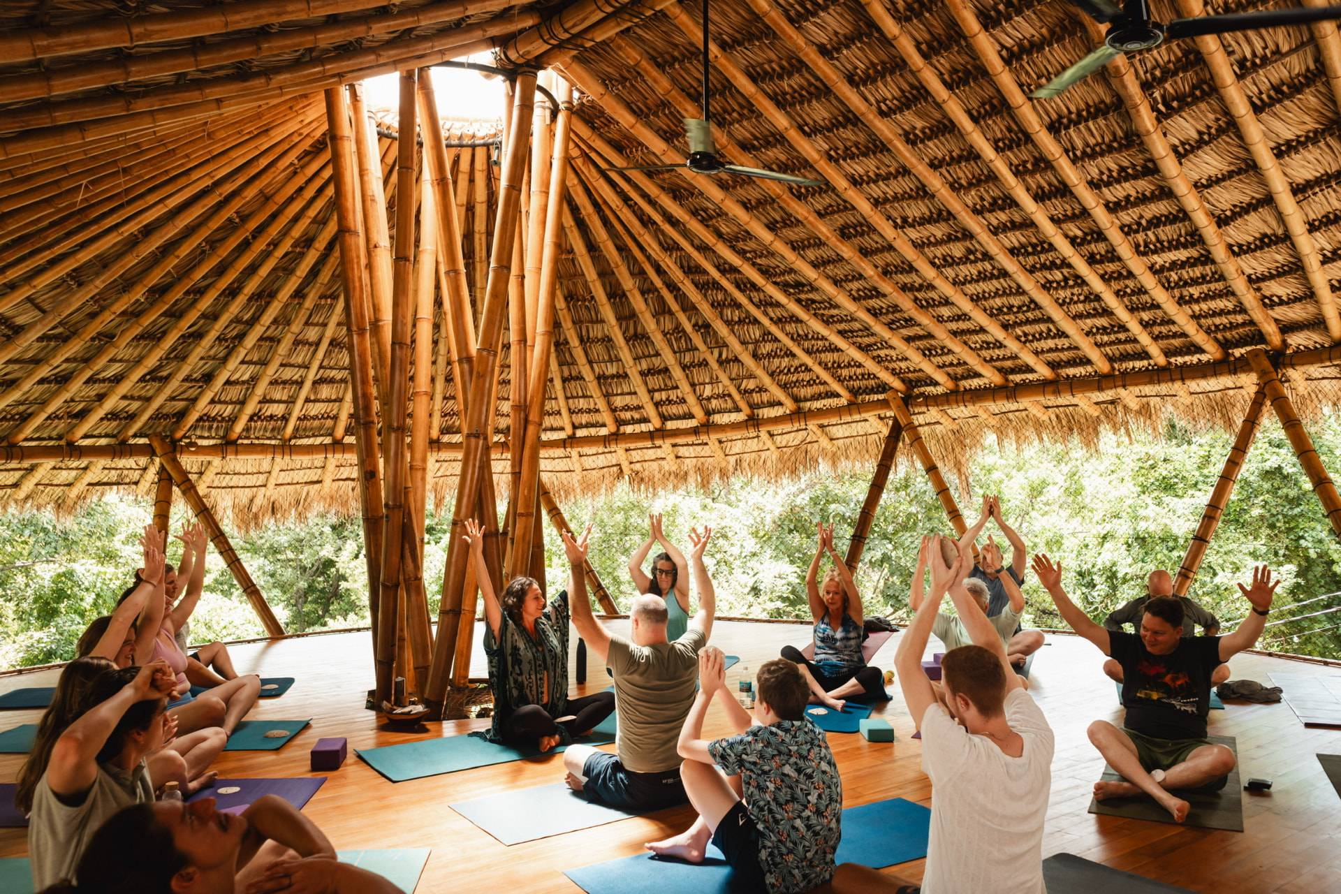 Retreat guests moving together in the open bamboo pavilion