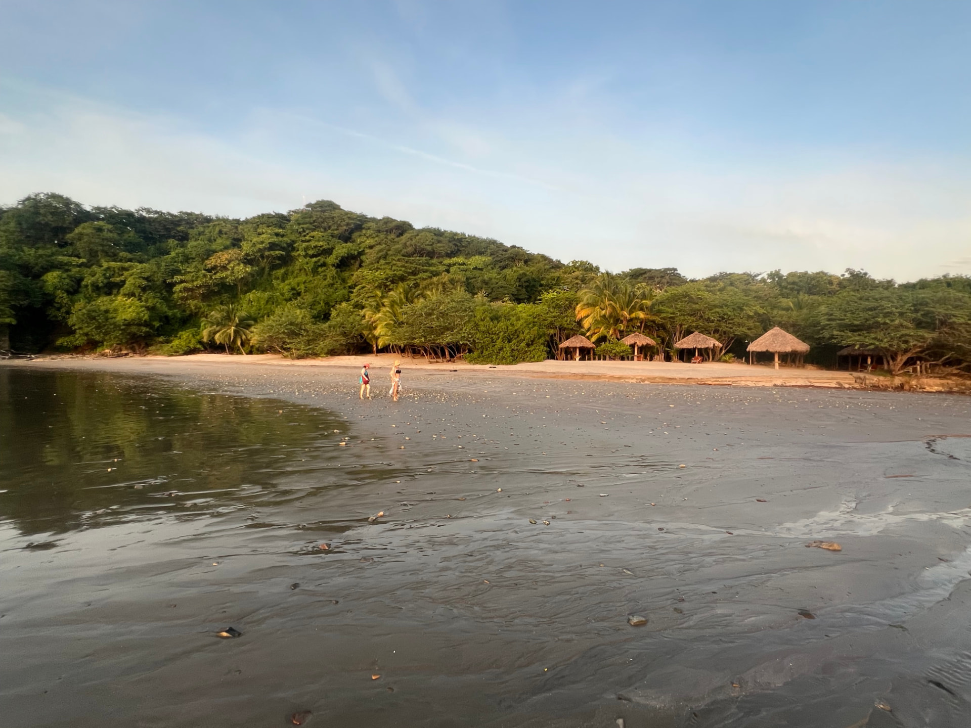 Retreat guests walking together across the wide beach at Playa El Coco