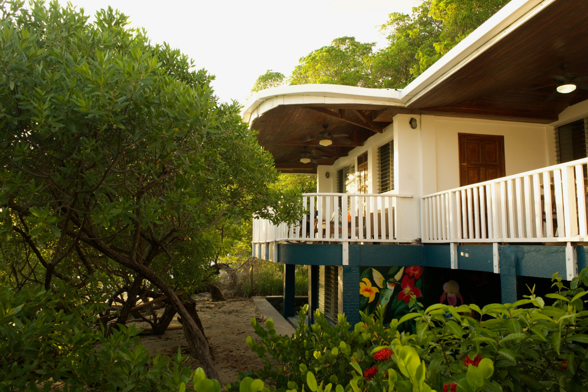 The beach-side outdoor area of the property with open-air seating and tropical planting