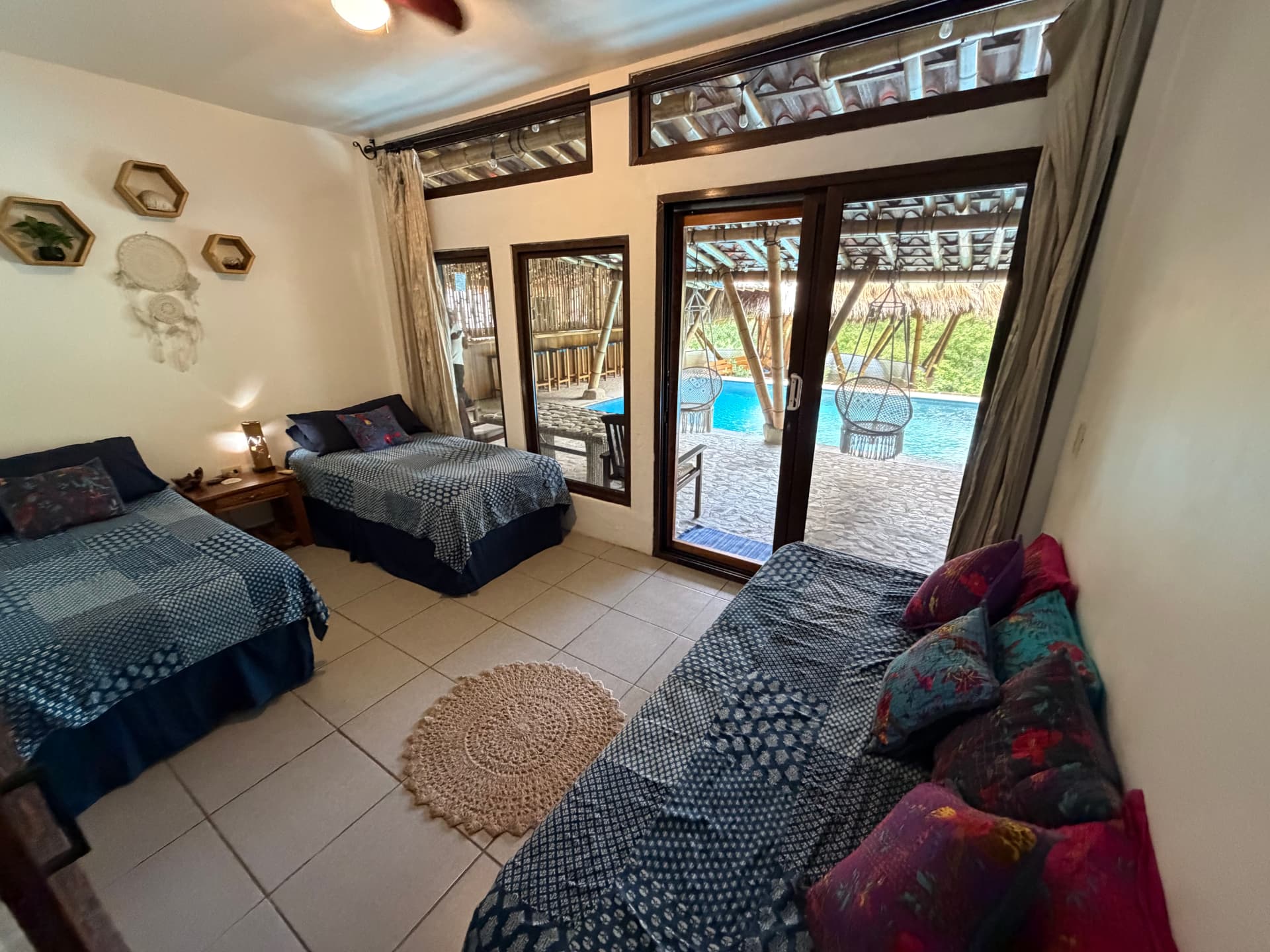 Guest room with separate beds and doors opening directly beside the pool