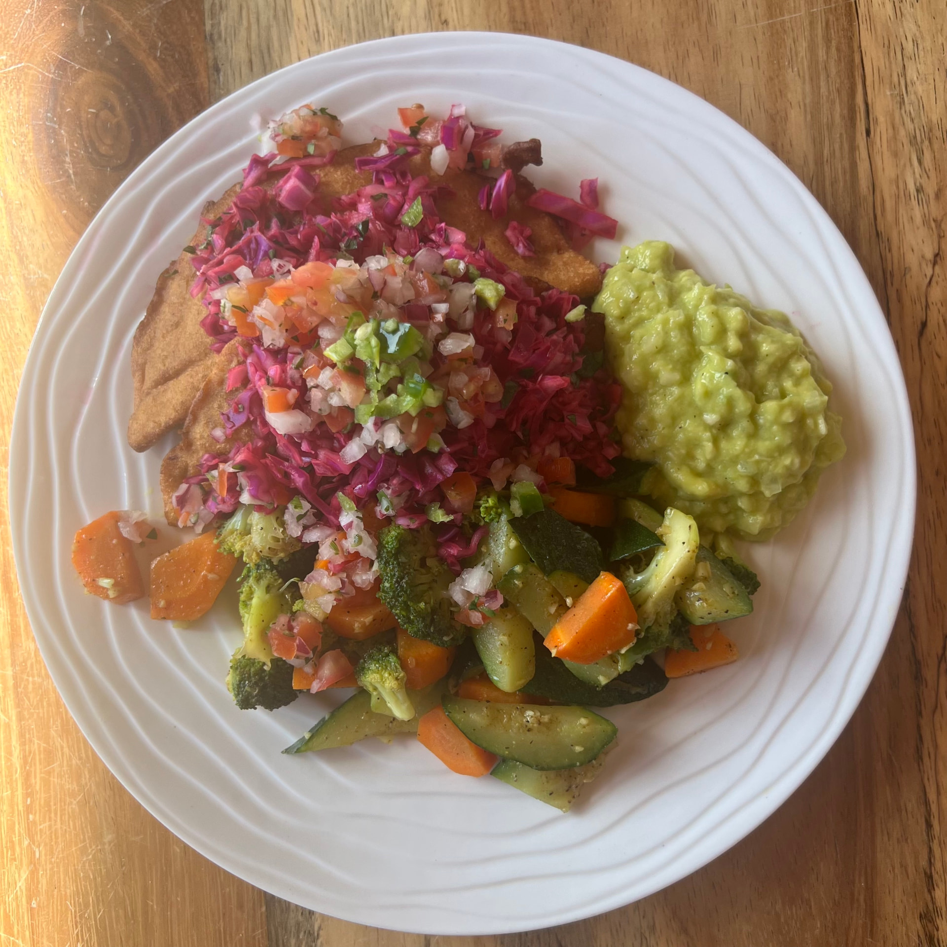 A colorful plated meal prepared with vegetables and fresh accompaniments